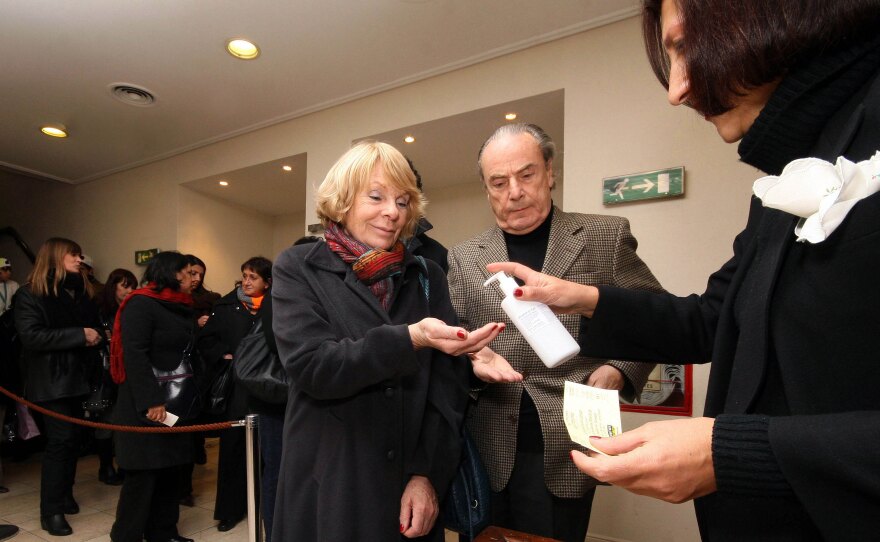 A couple uses hand sanitizer before entering the theater to see a performance <em>La Forma De Las Cosas</em>, or <em>The Way Things Are</em>, at the Multiteatro in Buenos Aires, Argentina. The swine flu epidemic has hit the country's once-vibrant theater industry particularly hard.