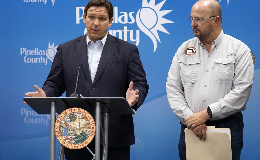 Florida Gov. Ron DeSantis, left, speaks as he stands with Kevin Guthrie, director of the Florida Division of Emergency Management, during a news conference, Monday, Sept. 26, 2022, in Largo, Fla.