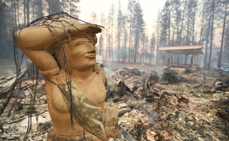 A statue stands amid the rubble of a smoldering property Thursday in Paradise, which was ravaged by the Camp Fire.