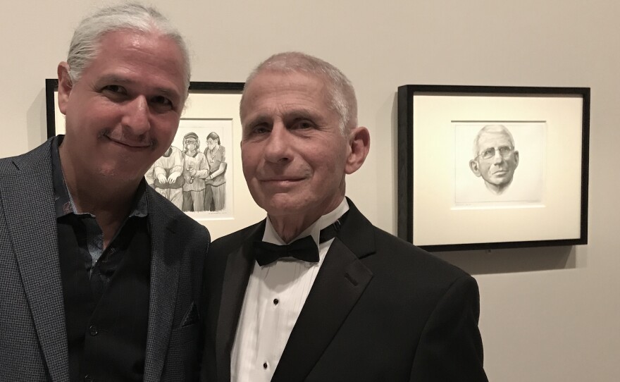 Artist Hugo Crosthwaite is shown with Dr. Anthony Fauci in front of sketches from Crosthwaite's stop-motion animation portrait of Fauci, at the Smithsonian National Portrait Gallery in an undated photo.