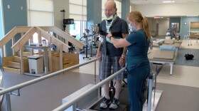 77-year-old Doug Bailey practices walking up a step inside the gym at the new Palomar Health Rehabilitation Institute in Escondido, July 15, 2021.