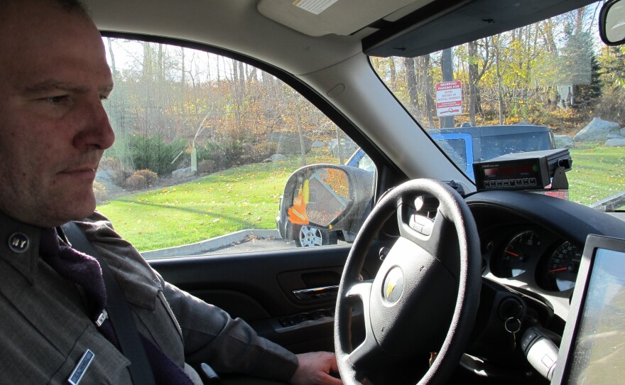 New York State Trooper Clayton Howell checks a screen that displays driving records inside his patrol SUV. The vehicle allows him to see whether passing drivers are on their phones. "It's a bird's-eye view," he says.