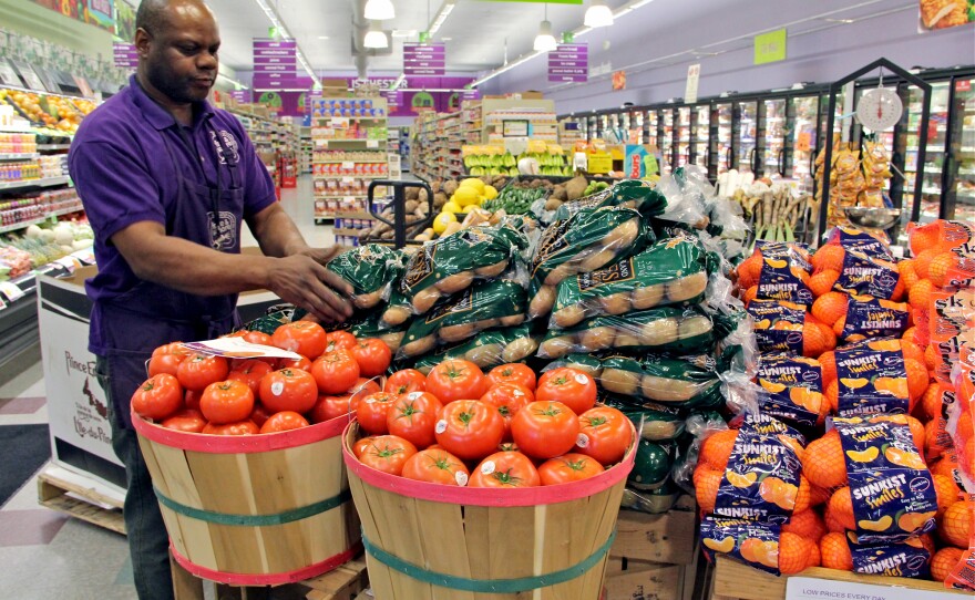 Produce manager Nate Sumpter arranges fresh fruits and vegetables at Fare and Square in Chester, Pa.