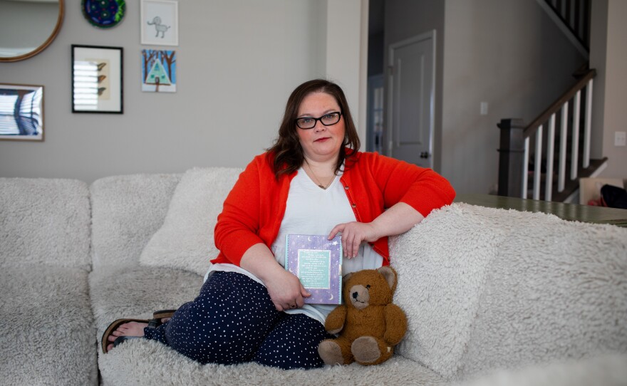 Meghan Britton holds her childhood journal and her brother's teddy bear at her home in Fort Wayne, Ind. The journal was given to her by her mother's friend after the death of her brother.