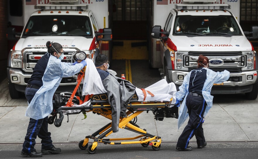 Patients are brought into Wyckoff Heights Medical Center by staff wearing personal protective gear due to COVID-19 concerns on Tuesday in the Brooklyn borough of New York.