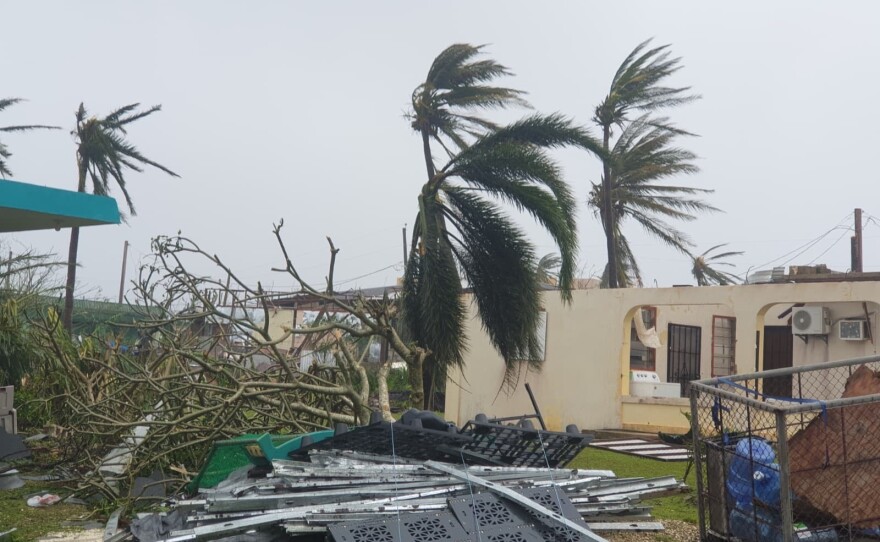 Debris covers the ground in Saipan on Wednesday as a super typhoon with ferocious winds and relentless rains, shredded tin roofs and forced residents to take cover from flying tree limbs.