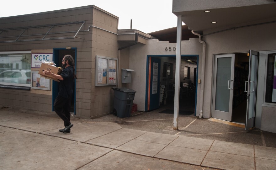 A man carries a box of food out of the Community Resource Center in Encinitas, Calif. April 7, 2025
