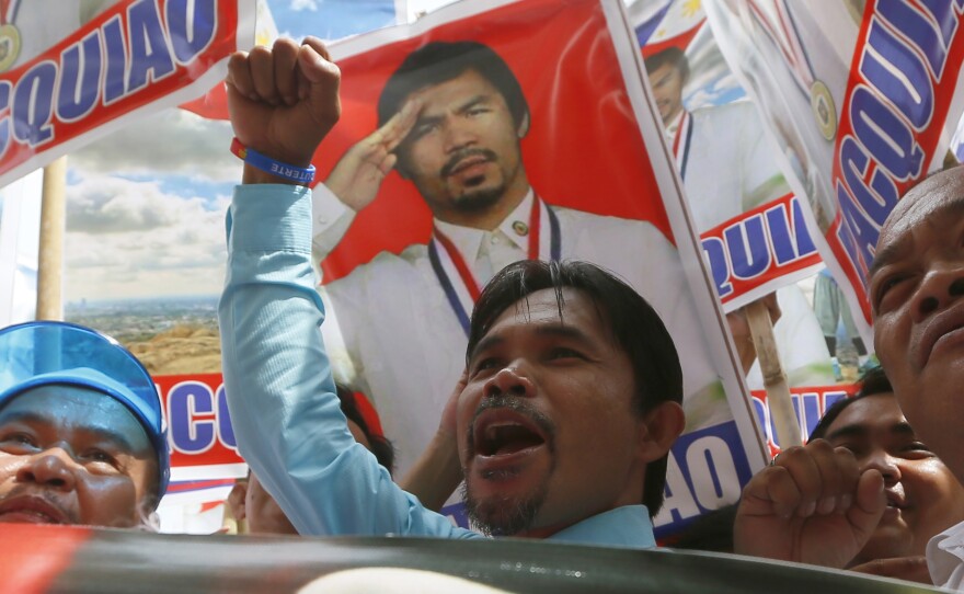 Johnny Dagami, Jr., an impersonator of Filipino boxer Manny Pacquiao, joins other supporters in Manila while Pacquiao files his certificate of candidacy as a senatorial candidate in next year's elections.