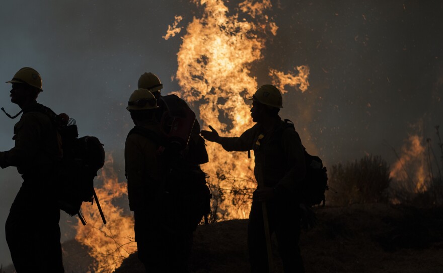 Firefighters monitor a controlled burn along Nacimiento-Fergusson Road to help contain the Dolan Fire near Big Sur, Calif., on Friday.