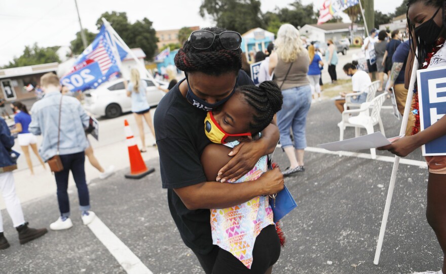 TAMPA: Monica Narain, left, hugs her daughter Elaina while dancing along with supporters of President-elect Joe Biden and Vice President-elect Kamala Harris during a party in front of the Casa Biden campaign office in the West Tampa neighborhood on November 7, 2020 in Tampa, Florida.