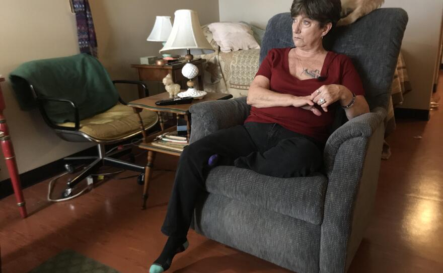 Nancygayle Gallaher sits in her apartment at Potiker City Heights Residence while her dog lies on the back of her chair, Feb. 15, 2019.