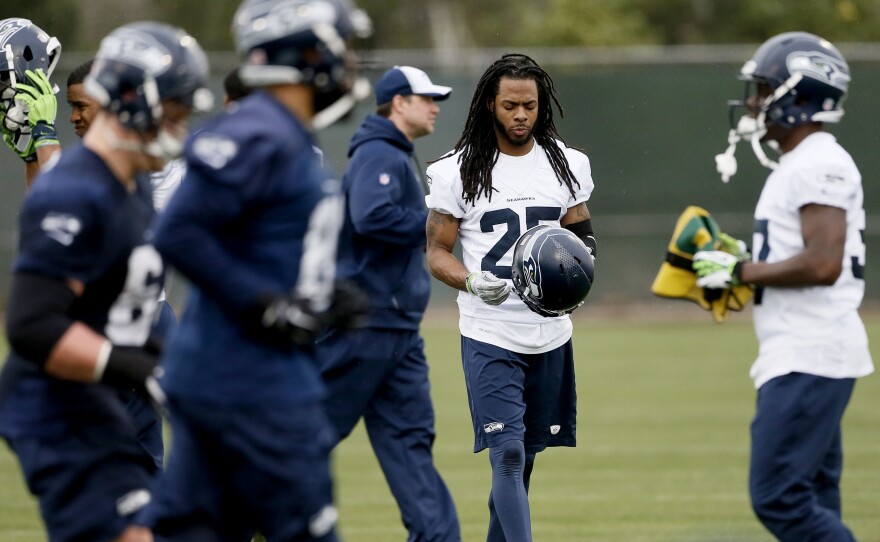 Seattle Seahawks' Richard Sherman puts his helmet on during a team practice for NFL Super Bowl XLIX football game, on Thursday.