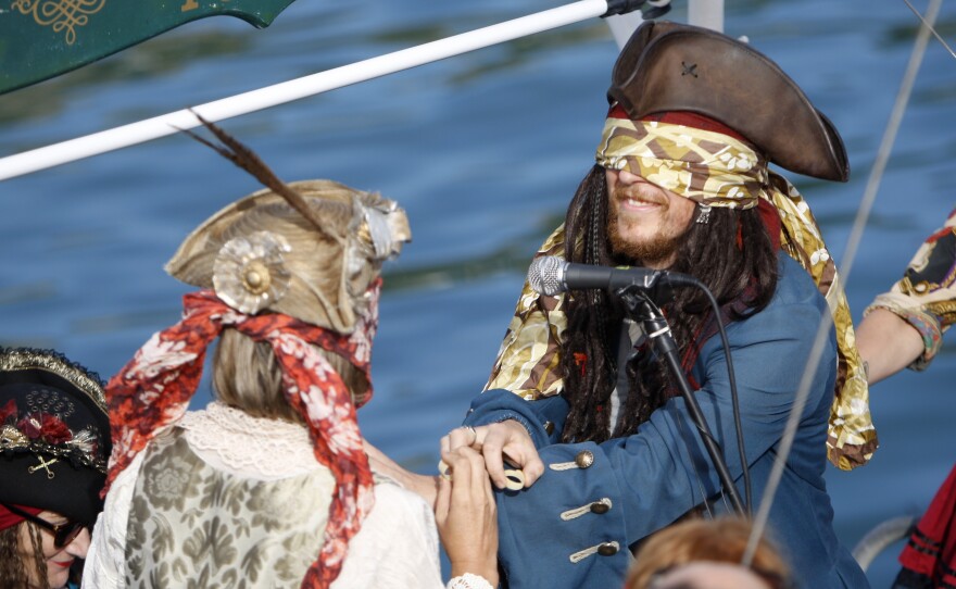 Bride Marianna Fenn (left) and bridegroom Toby Ricketts hold rings made of pasta during their marriage ceremony Saturday on a boat in Akaroa harbor, New Zealand.