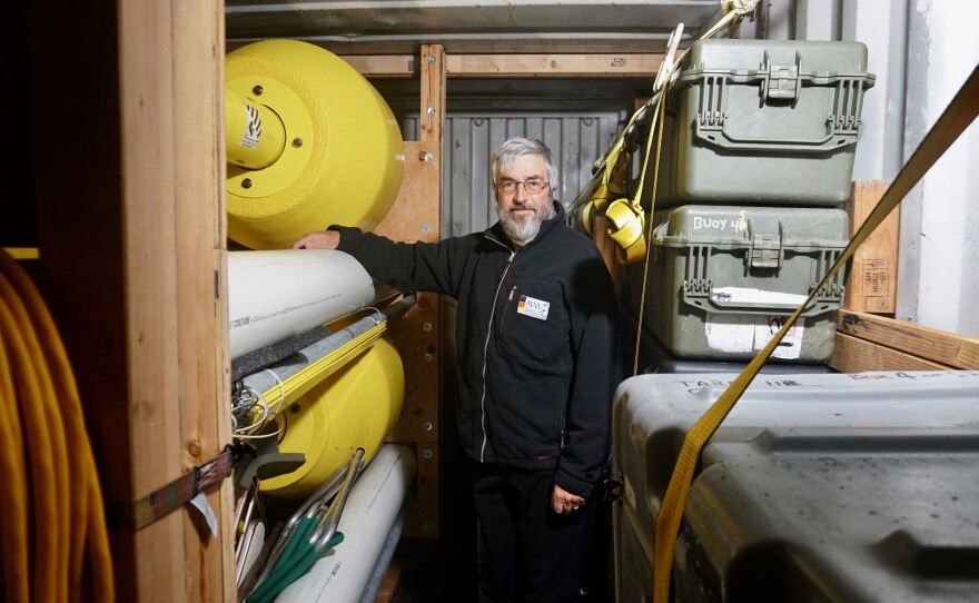 Ocean physicist Tim Stanton with the buoy system he's installing in the ice. The aim is to get a better sense of the ocean factors that may be driving Arctic ice melt.