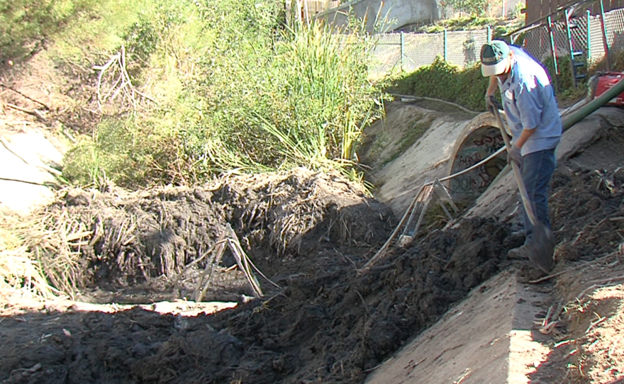 City of San Diego crews shovel mud from a storm water channel near Via de la Bandola in San Ysidro, Dec. 3, 2015.