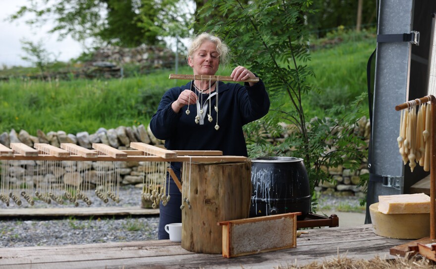 Ailbhe Gerrard dips her handmade wicks into beeswax to create candles at Brookfield Farms in County Tipperary, Ireland.