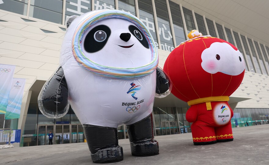 Staff members dressed up as Beijing 2022 Winter Olympics mascots Bing Dwen Dwen (left) and Shuey Rhon Rhon stand in front of the Main Media Center last month in Beijing.