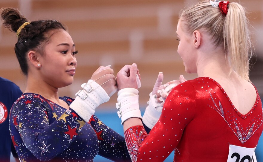 U.S. gymnasts Sunisa Lee and Jade Carey fist-bump during gymnastics qualifiers on Sunday at the Tokyo Olympics.