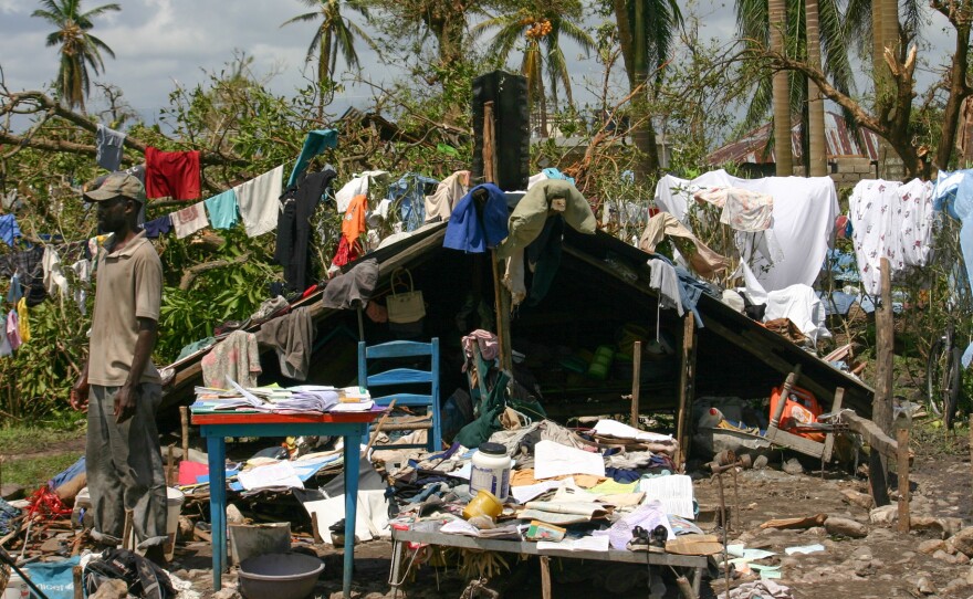 Gilbert Lorcy outside his home in Les Cayes. He was able to put the roof — which blew off in the storm — on the low stone walls of the foundation. His family spends days at the house and sleeps in a shelter at night.