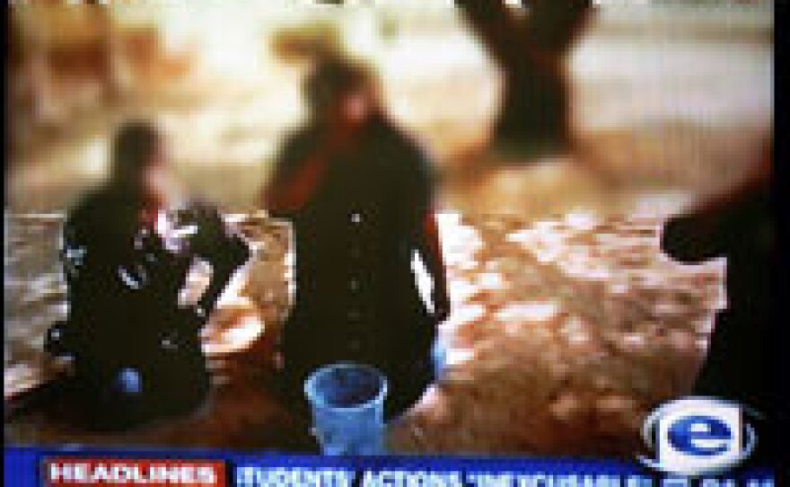 This TV grab taken from a South African news station shows a white university student forcing black workers to take part in degrading acts.
