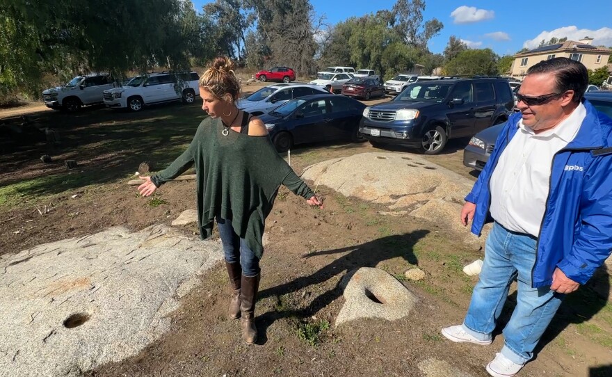 Marlise Kast-Myers is shown with KPBS reporter John Carroll at one of the many matade stones on the property on December 1, 2023.