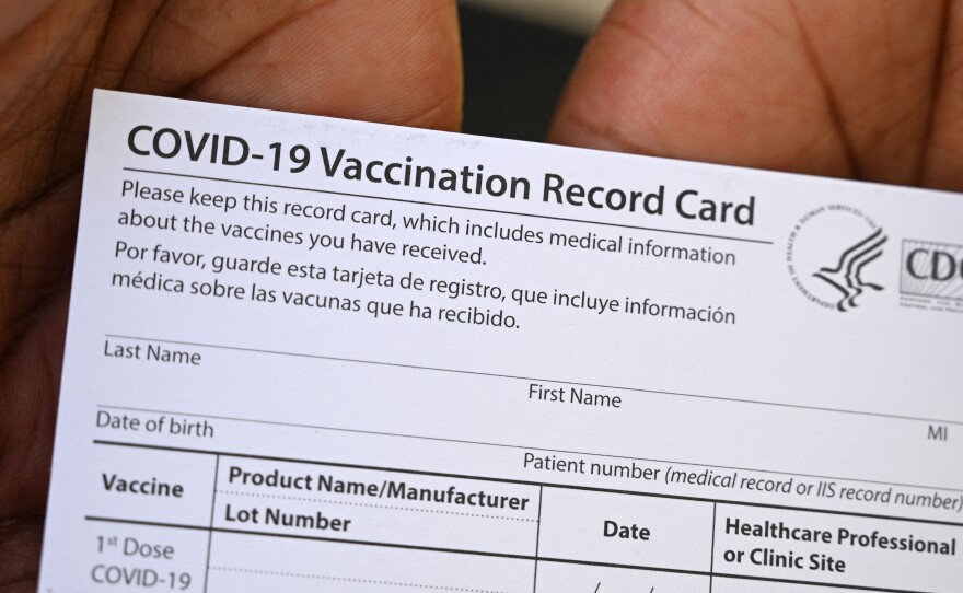 A healthcare worker displays a Covid-19 Vaccination Record Card at a health center in Los Angeles earlier this month.