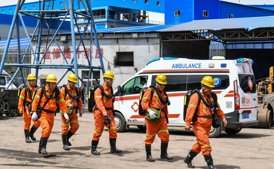 In this photo released by Xinhua News Agency, rescue workers pass by an ambulance in the aftermath of an explosion at Changzhi city's Liushenyu coal mine in Qinyuan county, northern China's Shanxi Province on Saturday, May 23, 2026.