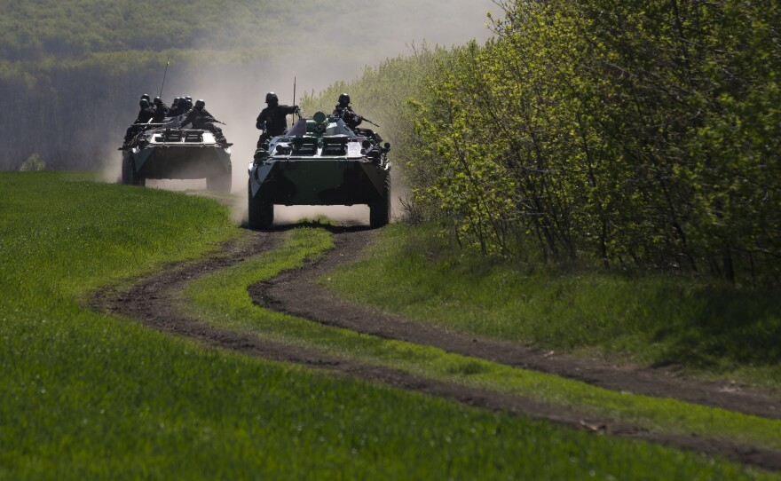 Ukrainian government armored personal carriers roll on a country road outside the town of Svyitohirsk near Slovyansk in eastern Ukraine Saturday.