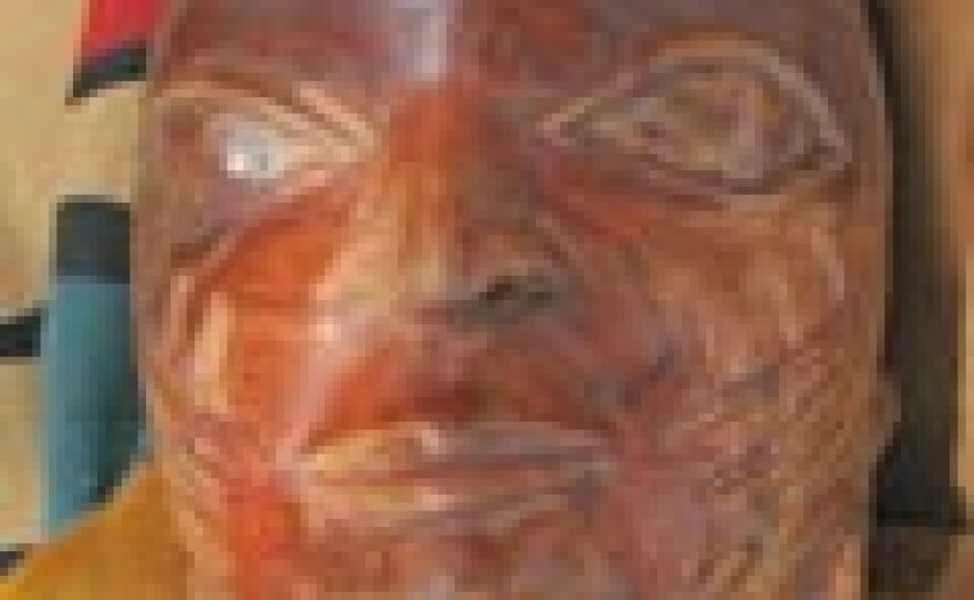 A bust of a voodoo god adorns one of the elaborate costumes of an Egungun dancer.