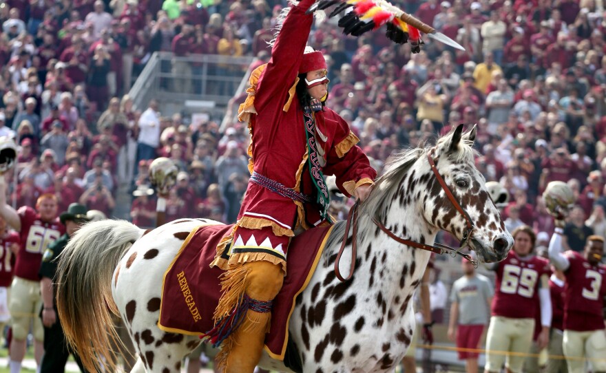 The student portraying Osceola wields his flaming torch at the FSU homecoming game.