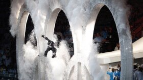 A snowboarder jumps through the Olympic rings during the opening ceremony.