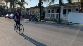 Ann King-Concialdi bikes through North Park while wearing a face covering, April 21, 2020.