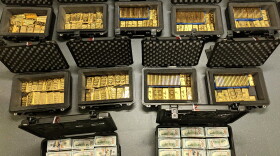 This image provided by U.S. Department of Justice, and contained in a court filing, shows gold bars and cash that was seized from a David J. Rush's home, during a search on May 19, 2026, in Ashburn, Va.