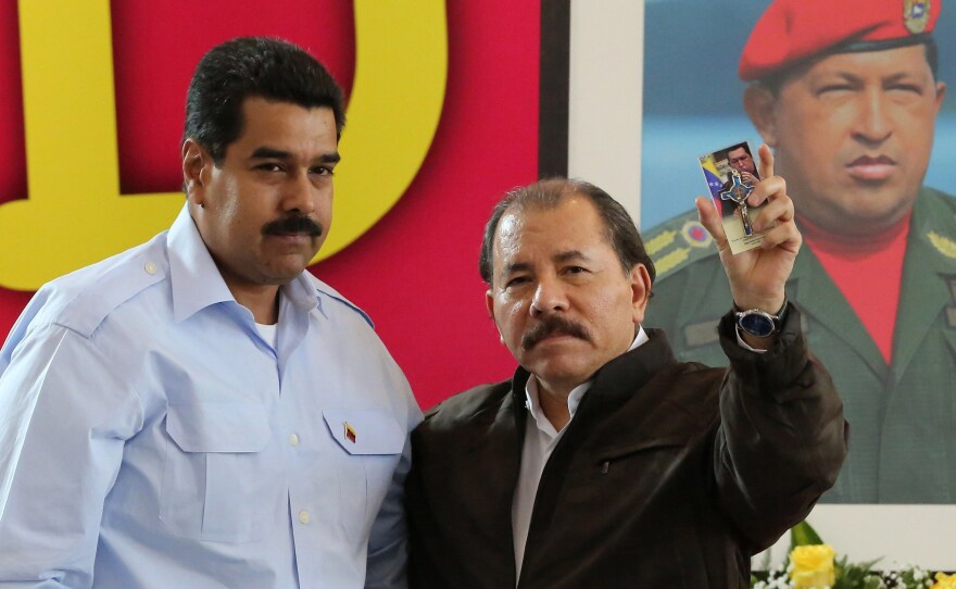 Nicaraguan President Daniel Ortega (right) and his Venezuelan counterpart Nicolas Maduro stand in front of a picture of late Venezuelan President Hugo Chavez, during a summit in Managua on June 29.