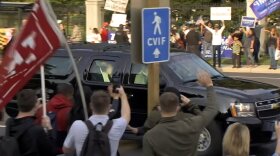 President Donald Trump waves as he drives past supporters gathered outside Walter Reed National Military Medical Center in Bethesda, Md., Sunday, Oct. 4, 2020.