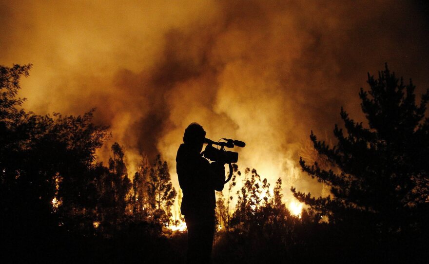 A cameraman films the fire on the outskirts of Valparaiso early Saturday. The blaze has threatened various neighborhoods and more than 4,000 people have been evacuated from their homes.