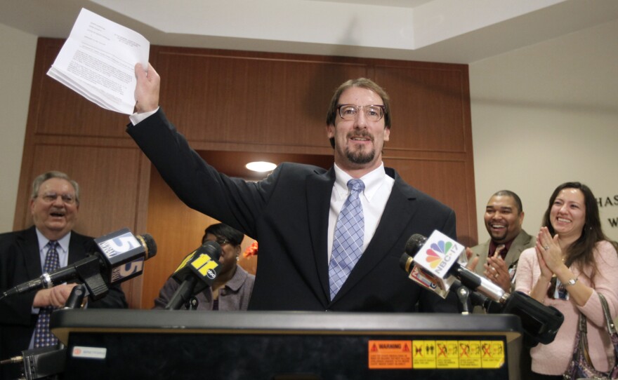 Greg Taylor holds up his release papers after he was unanimously exonerated by a three-judge panel in Raleigh, N.C., in 2010. Taylor, who had been in prison since 1993 for murder, is now suing several people who worked at a crime lab, claiming their erroneous findings landed him in jail.