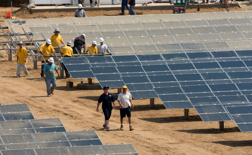 Workers install a solar farm outside Sacramento, Calif. The state aims to attain half of its electricity from renewable sources by 2030.