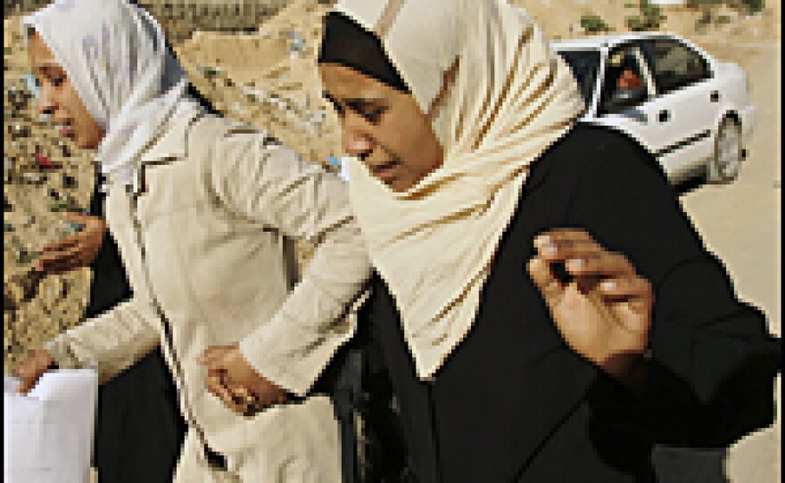 Palestinian girls flee an area were members of the Al-Qassam military wing of Hamas clashed with presidential guards Dec. 17, 2006, in Gaza City.