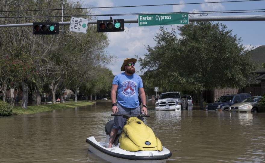 Rabon Raulerson stands on the personal watercraft he has been using to help flood victims on the west side of Houston check out their homes and salvage what they can.