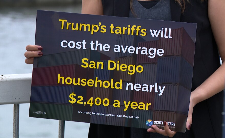 A sign is shown that says “Trump’s tariffs will cost the average San Diego household nearly $2,400 a year – According to the nonpartisan Yale <a href="https://budgetlab.yale.edu/">Budget Lab</a>," at Cesar Chavez Park Pier on August 13, 2025.
