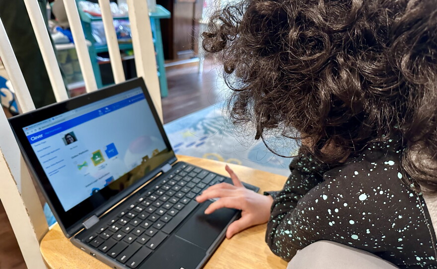 A San Diego Unified School District student works on her school-issued laptop computer to complete an assignment at home in San Diego on May 23, 2023.