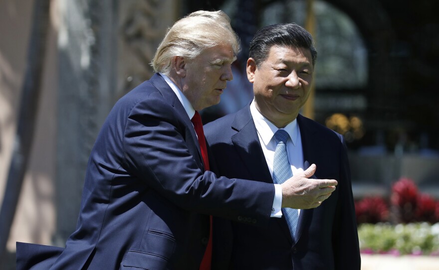 President Donald Trump and his Chinese counterpart President Xi Jinping walk together at Mar-a-Lago in Florida on April 7.