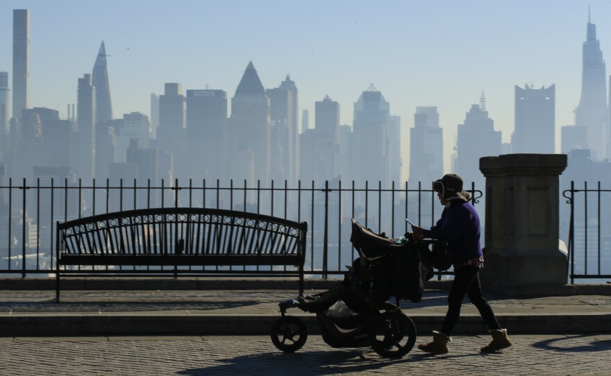 Amazon and Target are among the latest big retailers to stop selling weighted infant sleepwear due to concerns about safety. Here, a woman pushes a stroller as the New York skyline is seen from Weehawken, New Jersey.