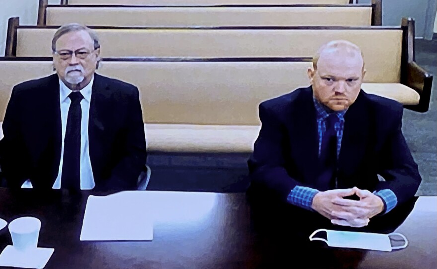 Gregory and Travis McMichael, who are father and son, attend a bond hearing in Nov. 2020. The McMichaels and William "Roddie" Bryan are on trial for the murder of Ahmaud Arbery.
