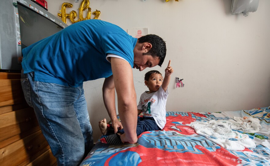 Ferley Sáenz, a 40-year-old coordinator of Bogotá's transportation system, dresses his son Jeronimo for the day. Sáenz admits that his wife assumes most of the child care and household chores. For years, he considered this the norm, spending most of his days at work or with friends. Now he's trying to step up.