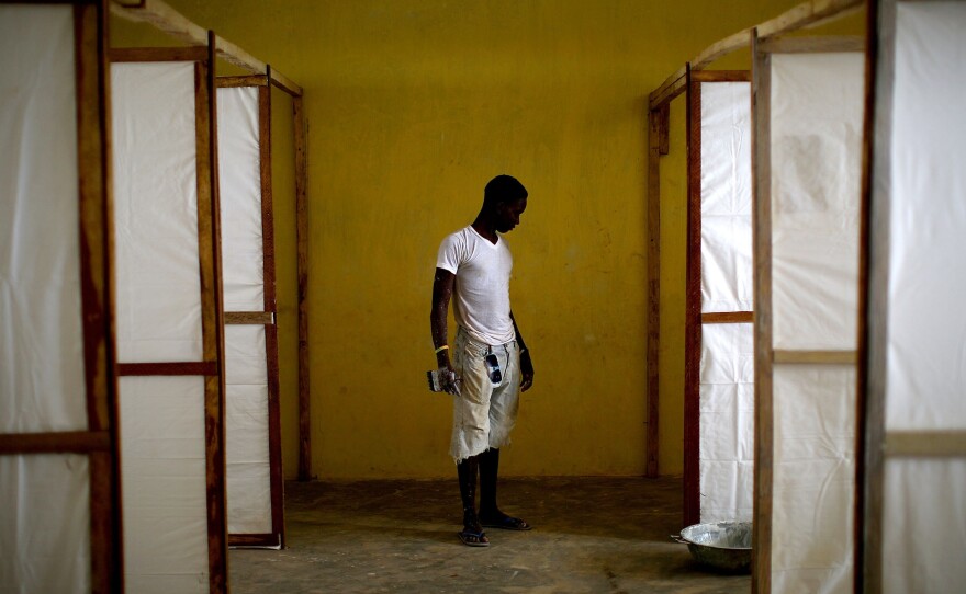 A worker puts the finishing touches on the dividers that will separate patients at the community care center in the Port Loko District of Sierra Leone.