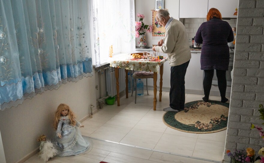 Viktor Lada and Svitlana Domoratska, a social worker, in the kitchen of the Ladas' new apartment. The Ladas were able to bring a few items from their old home, but many were damaged in the strike.