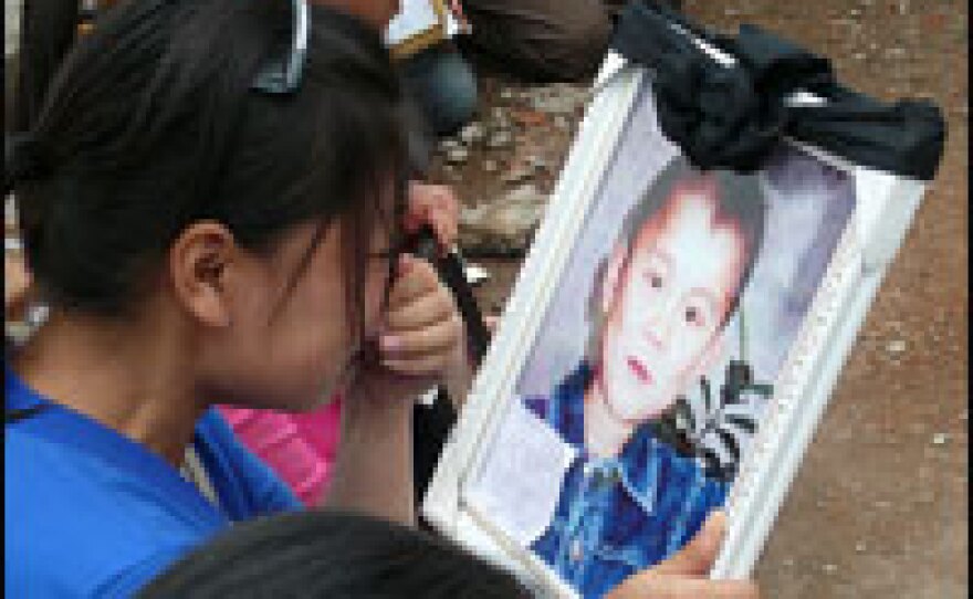 One mother cries as she looks at a picture of her son she lost in the earthquake.