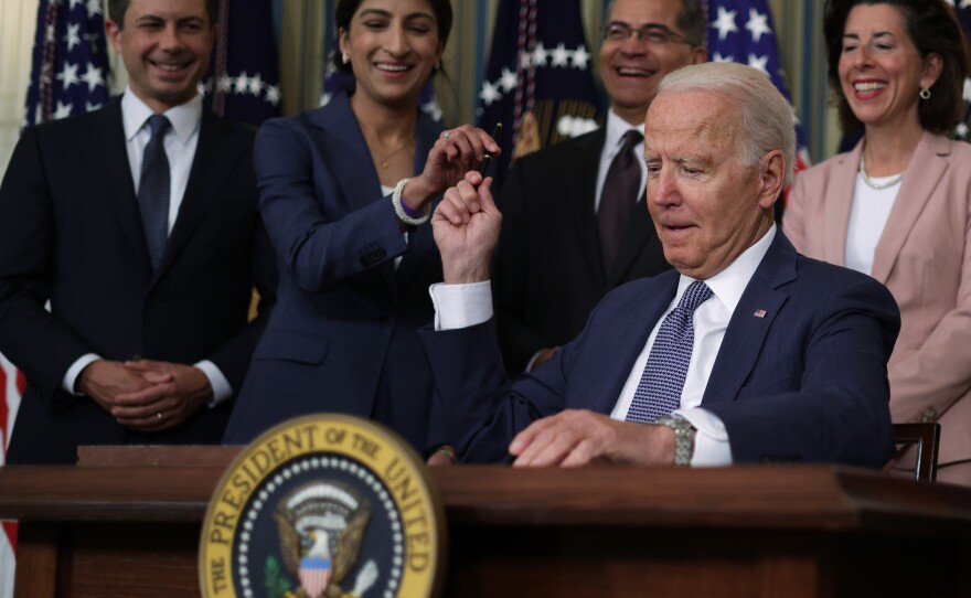 President Joe Biden passes a signing pen to Chairperson of the Federal Trade Commission Lina Khan (2nd L) at the White House on July 9, 2021. President Biden signed an executive order on "promoting competition in the American economy."